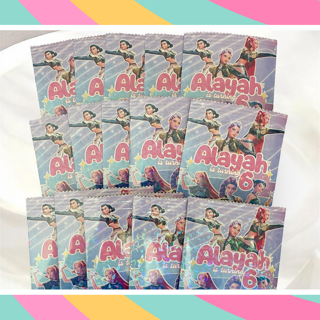 Multiple personalized party favor bags with a superhero design and 'Alayah is turning 6' text.
