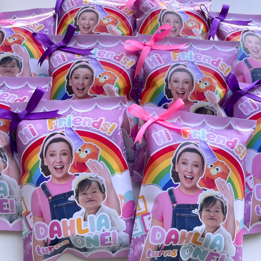 Party favor bags with 'Hi Friends!' text and colorful designs, featuring a child's face and rainbow elements.